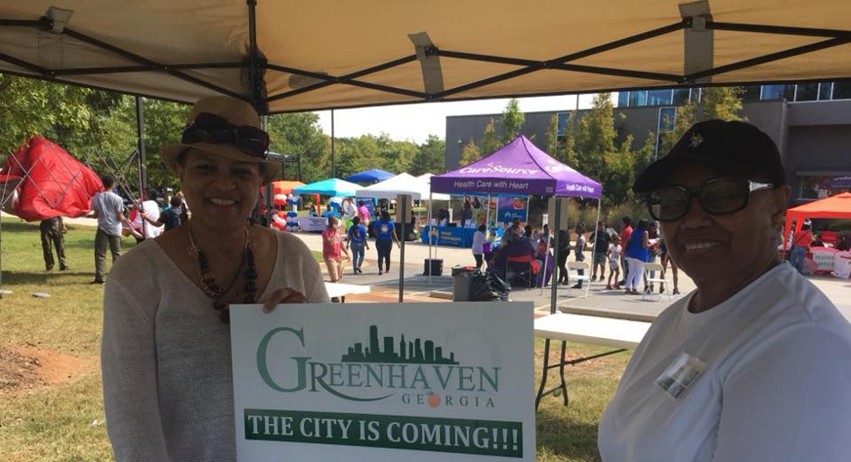 Kathryn Rice, who is leading the movement to form the city of Greenhaven, holds up a sign with a volunteer.