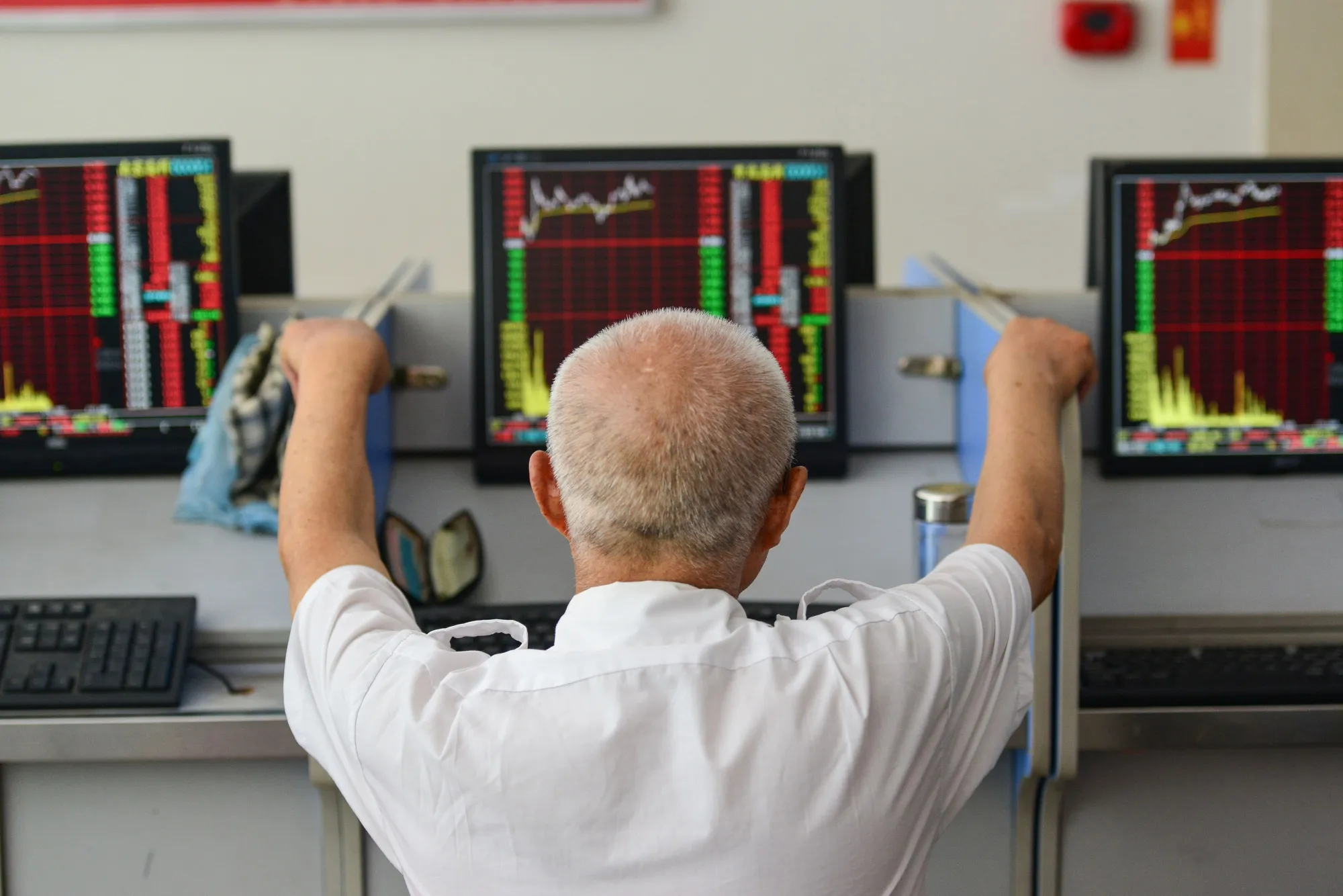 An investor looks at screens showing stock market movements in Fuyang, China.&nbsp;