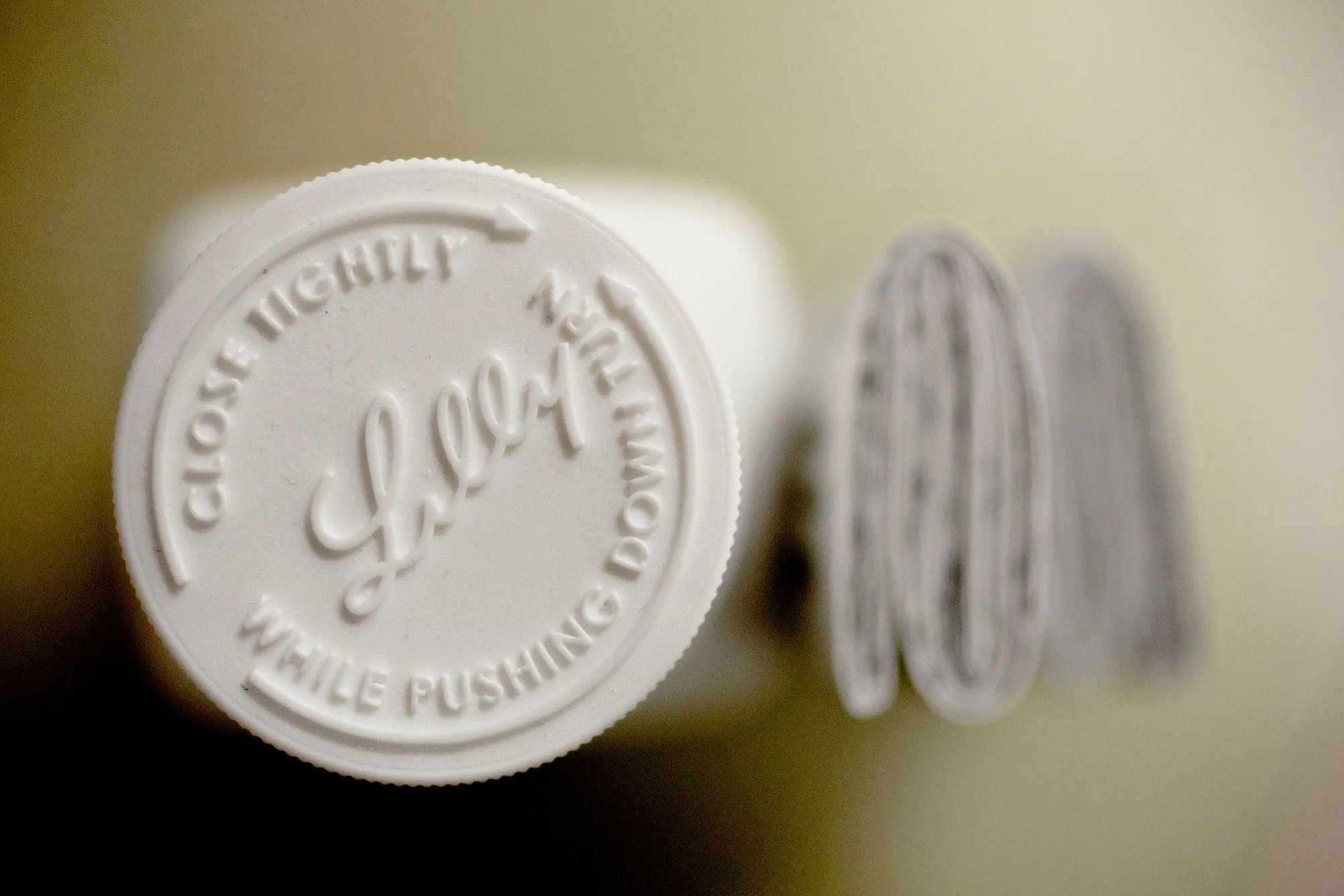 An Eli Lilly & Co. logo on the cap of a pill bottle.