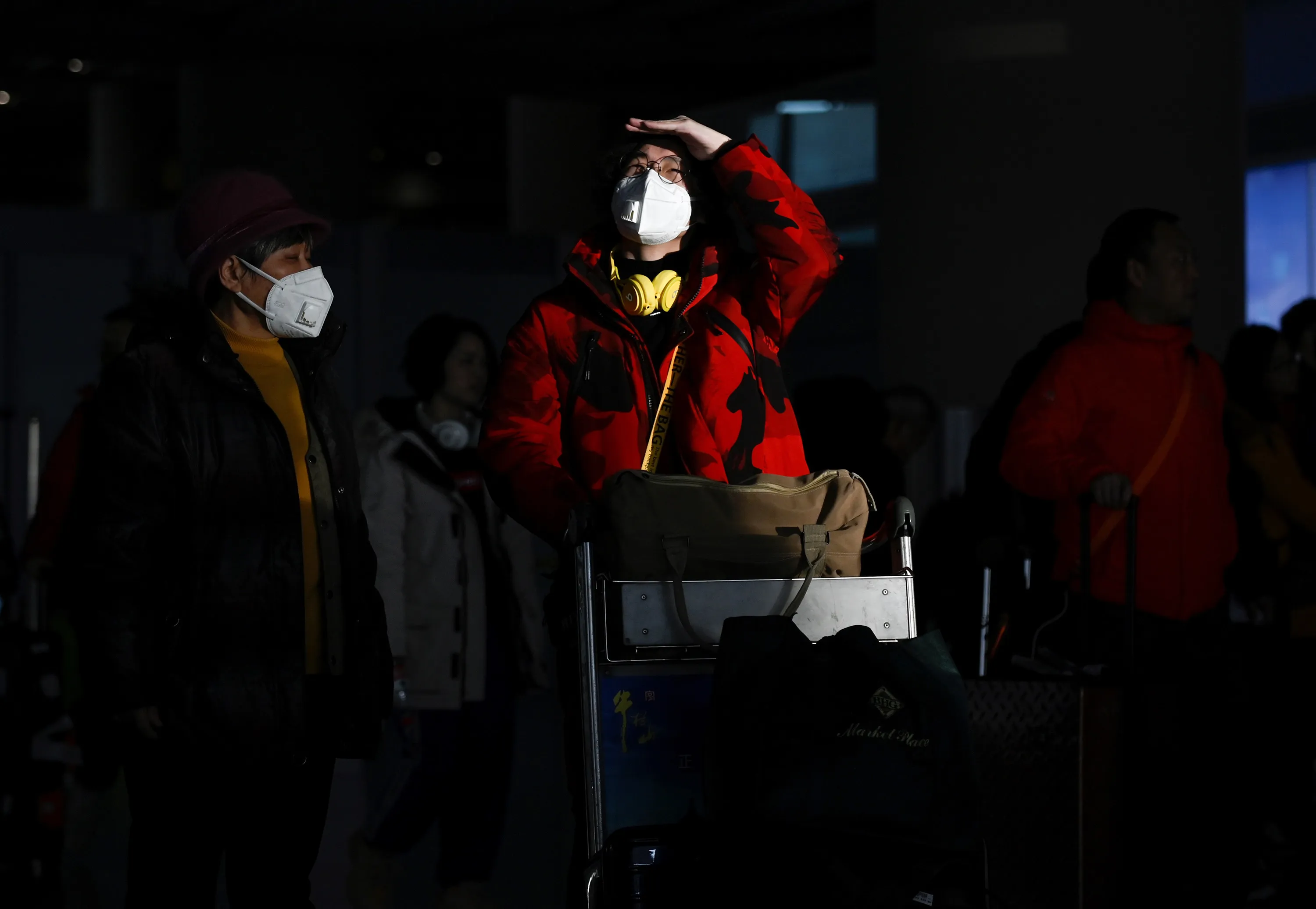 Passengers wearing masks arrive at Beijing International Airport on Jan. 20.