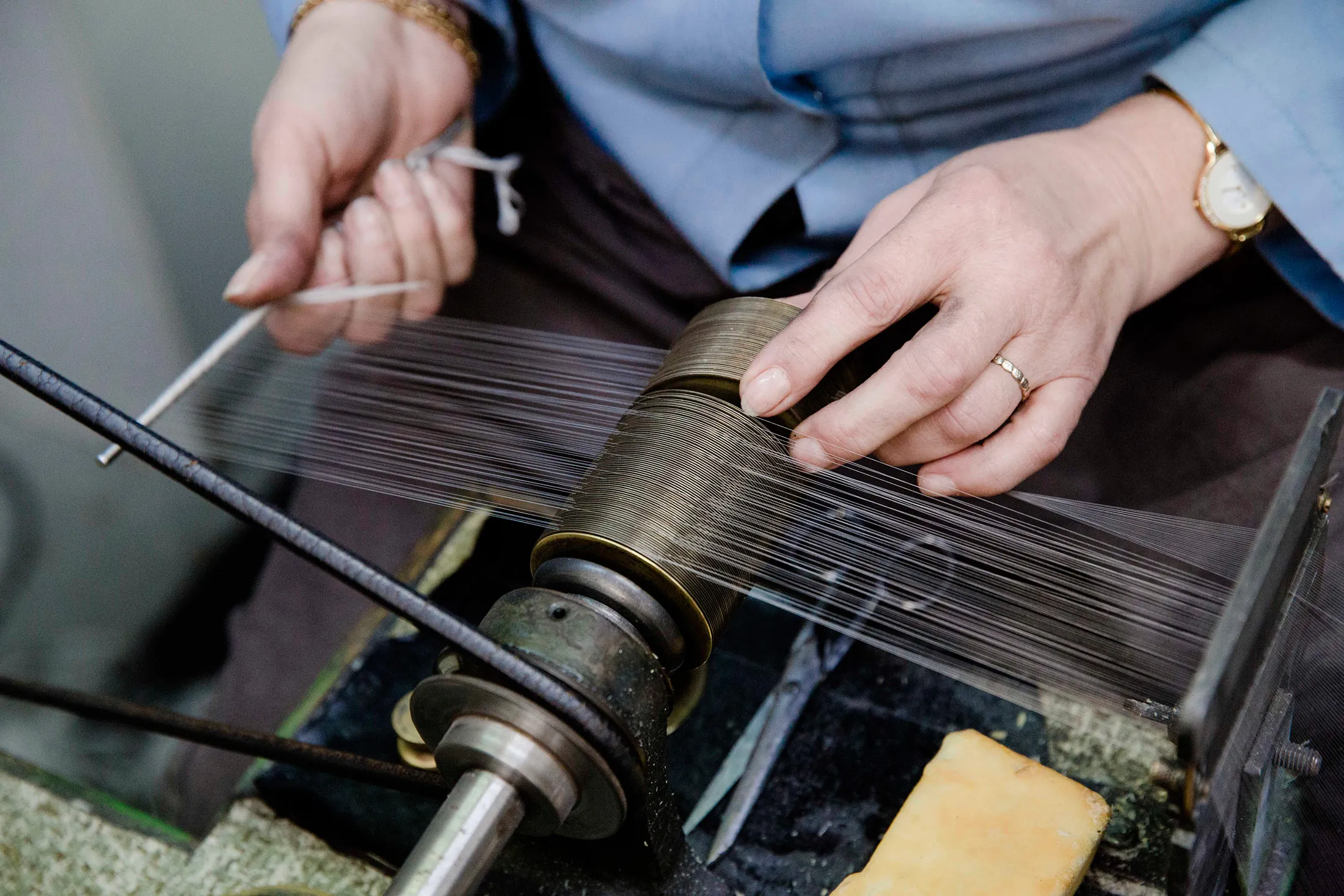 An employee uses a yarn bobbin to separate lace strands inside a factory in Calais.
