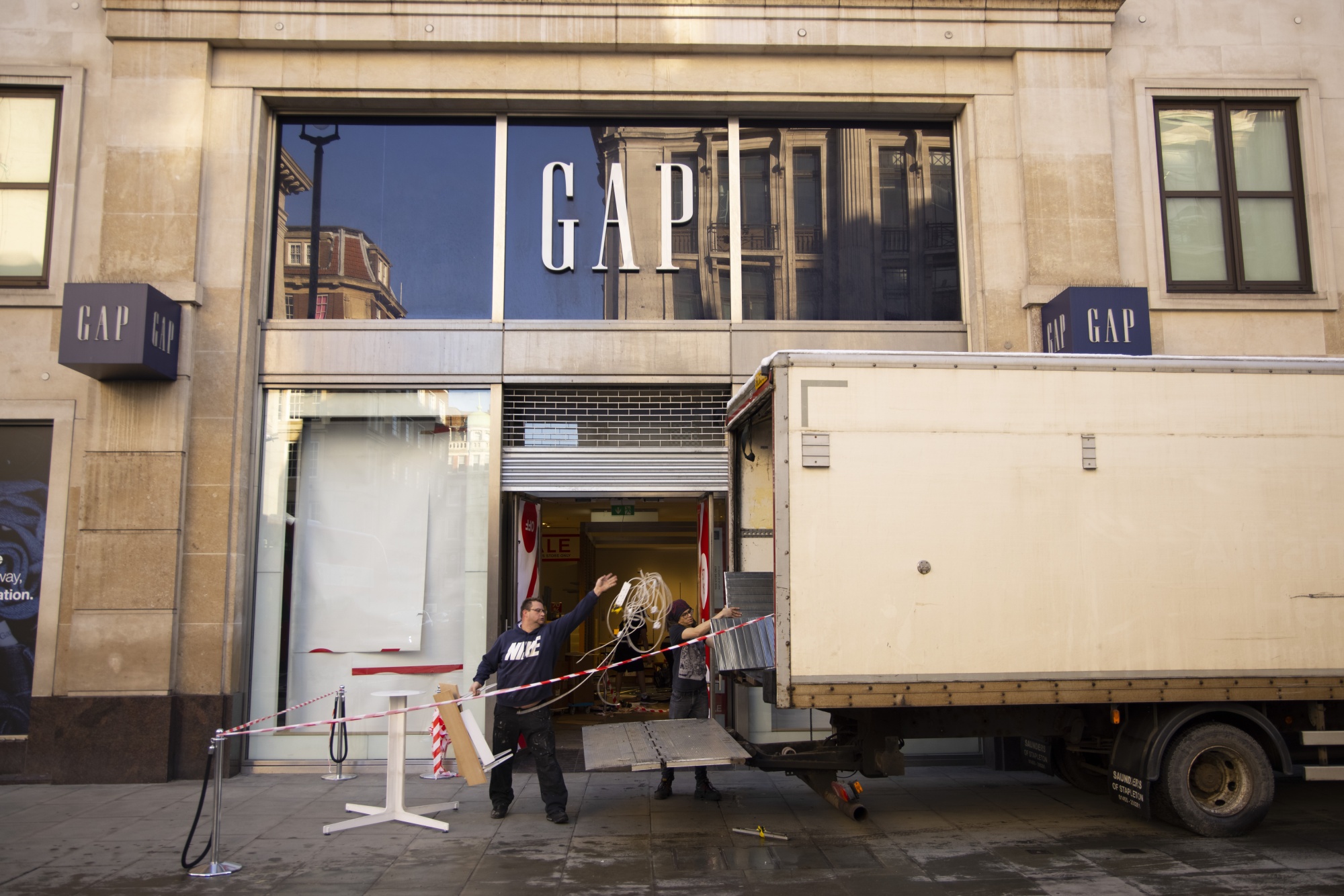 Workers remove shop fittings from a closed Gap store in London.