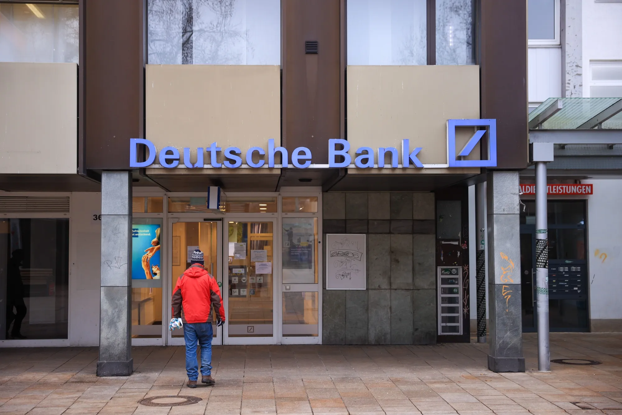 A customer enters a branch of Deutsche Bank AG in Wolfsburg.