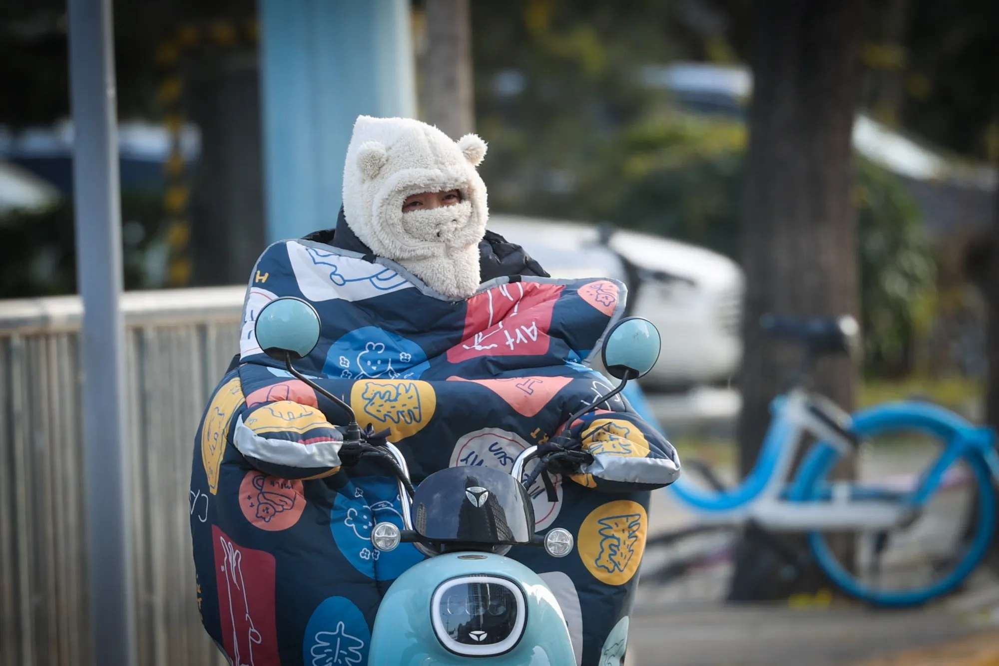 A woman covered in warm clothes rides on the street in Beijing&nbsp;on Nov. 29, 2022