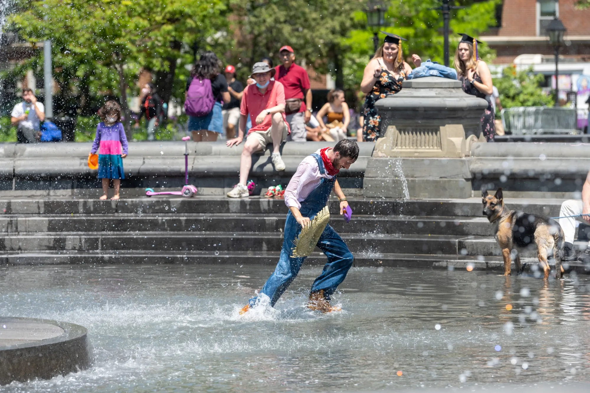 A man dressed in a scarecrow costume runs through the fountain in Washington Square Park on May 25, 2021.