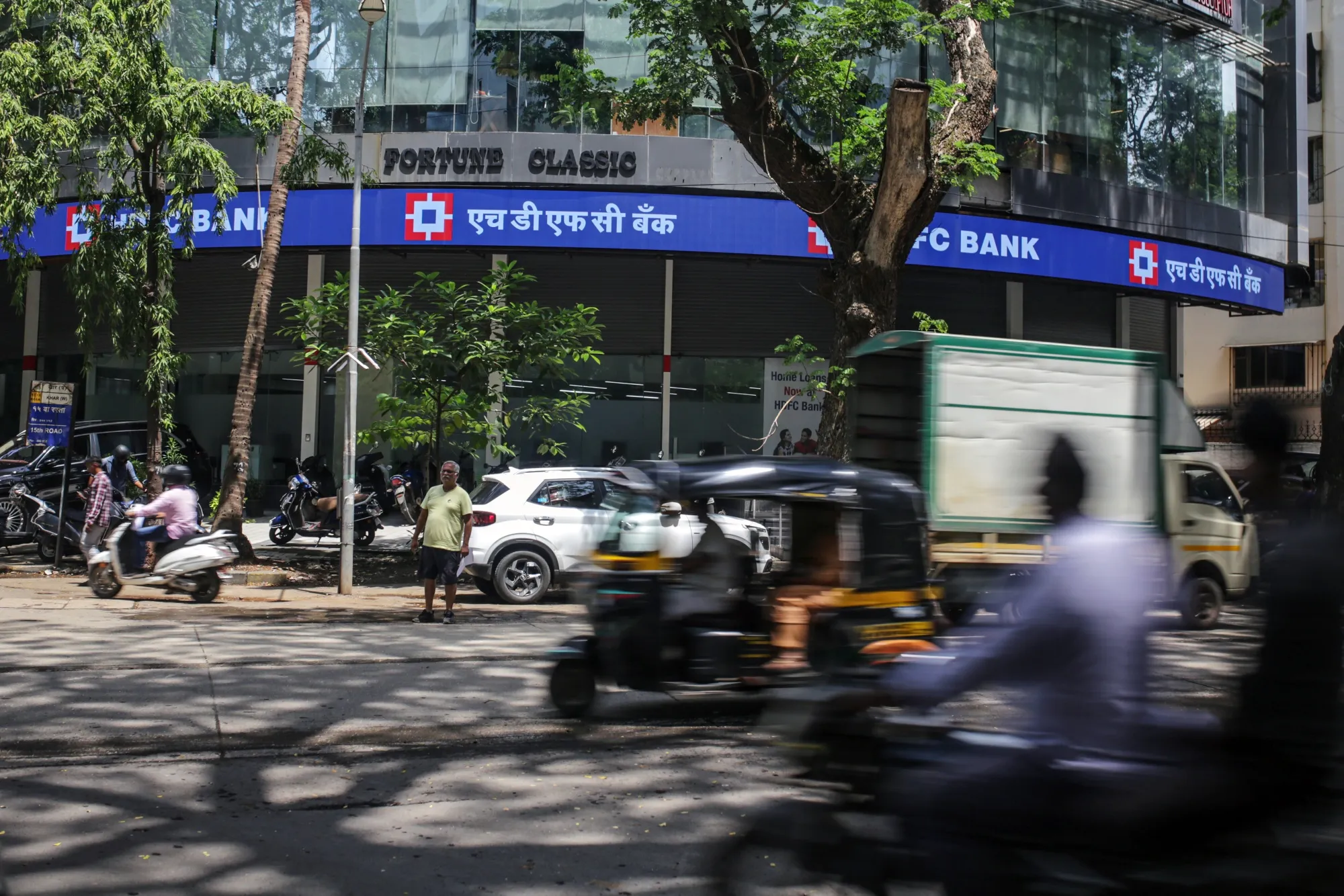 Vehicles drive past a HDFC Bank Ltd. bank branch in Mumbai, India.