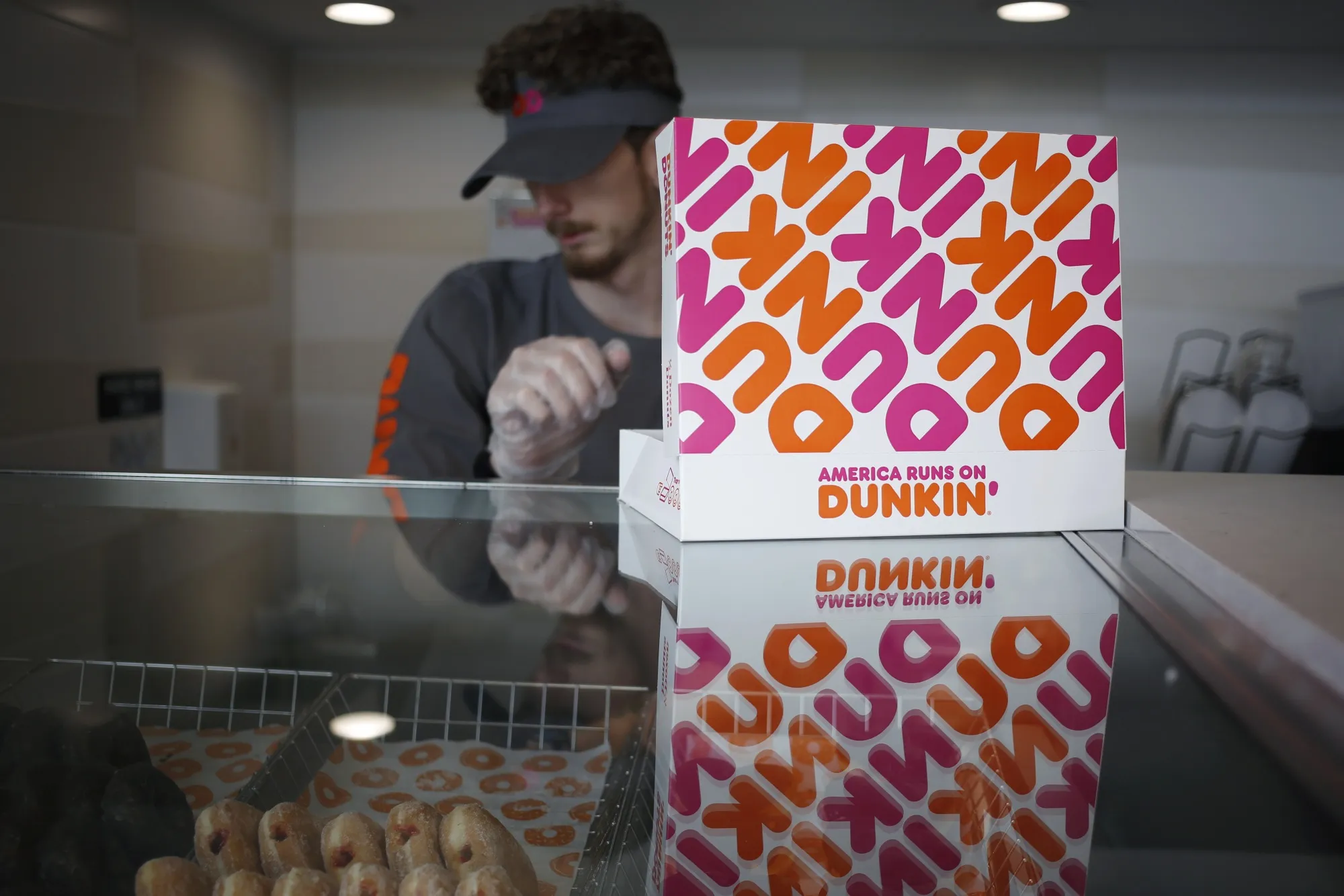 An employee fills a box with donuts inside a Dunkin' location in Mount Washington, Kentucky.