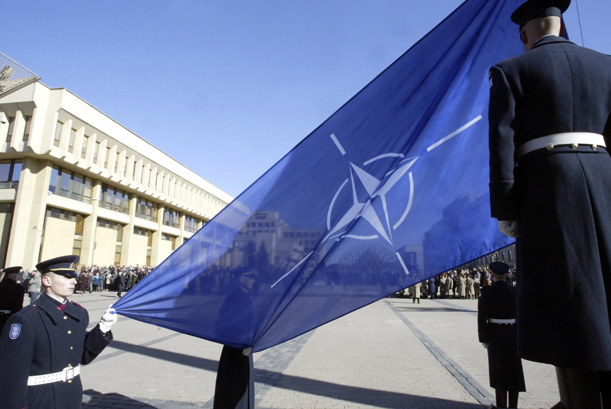 Soldiers hoist a blue-and-white NATO flag&nbsp;in Vilnius, Lithuania.&nbsp;