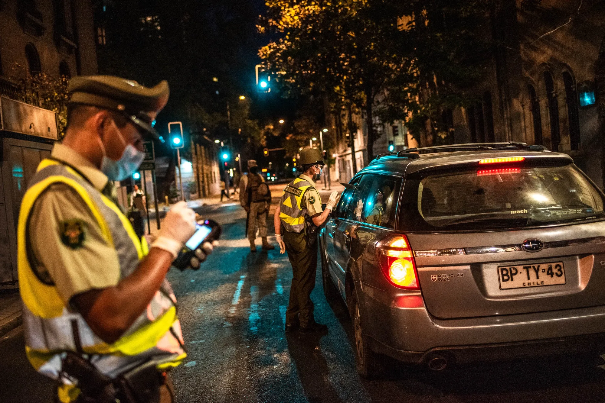 Police officers check to see if driver’s got their permits to drive through downtown Santiago.