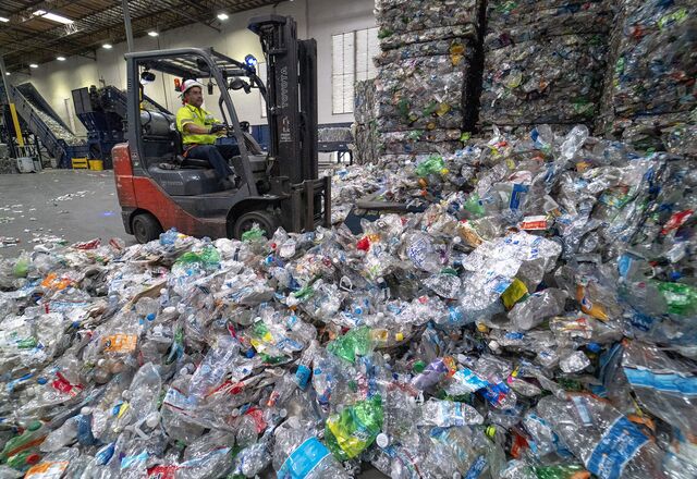 A forklift driver transports mounds of plastic bottles at rPlanet Earth’s recycling plant in Vernon, Calif.
