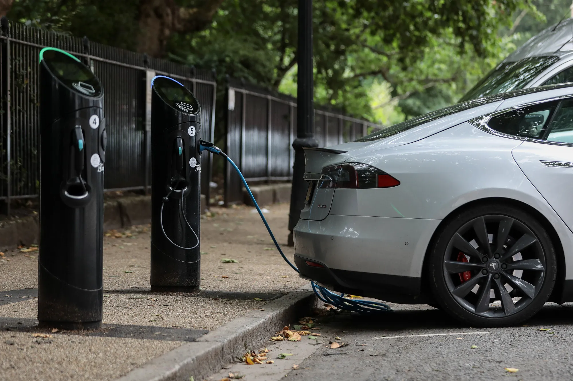 A charging plugs connects a Tesla Inc. Model S electric vehicle to a Source charging station in London.