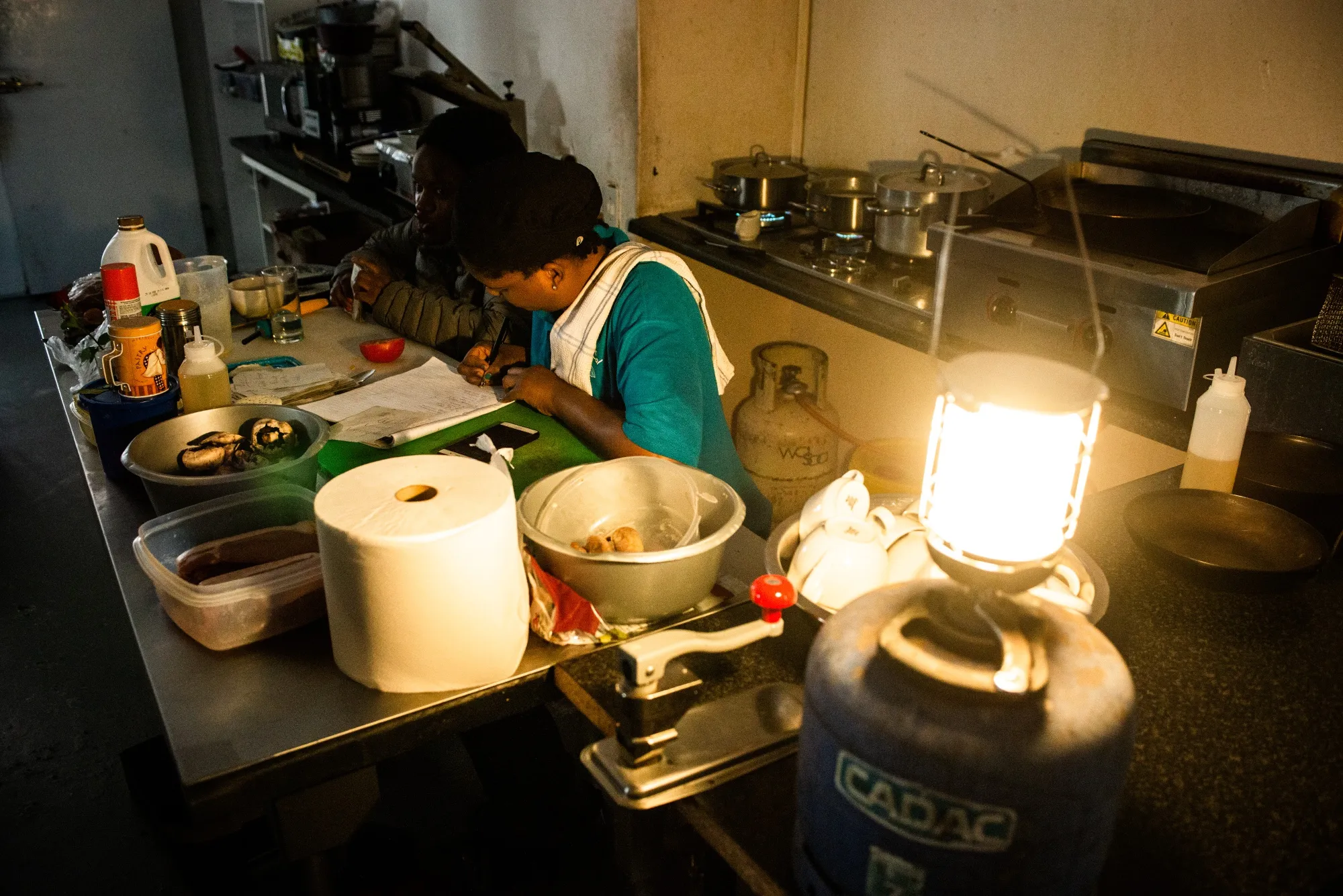 Workers in a cafe use an emergency gas-powered lamp to illuminate the kitchen after a&nbsp;power outage&nbsp;in Johannesburg&nbsp;on Feb. 14.