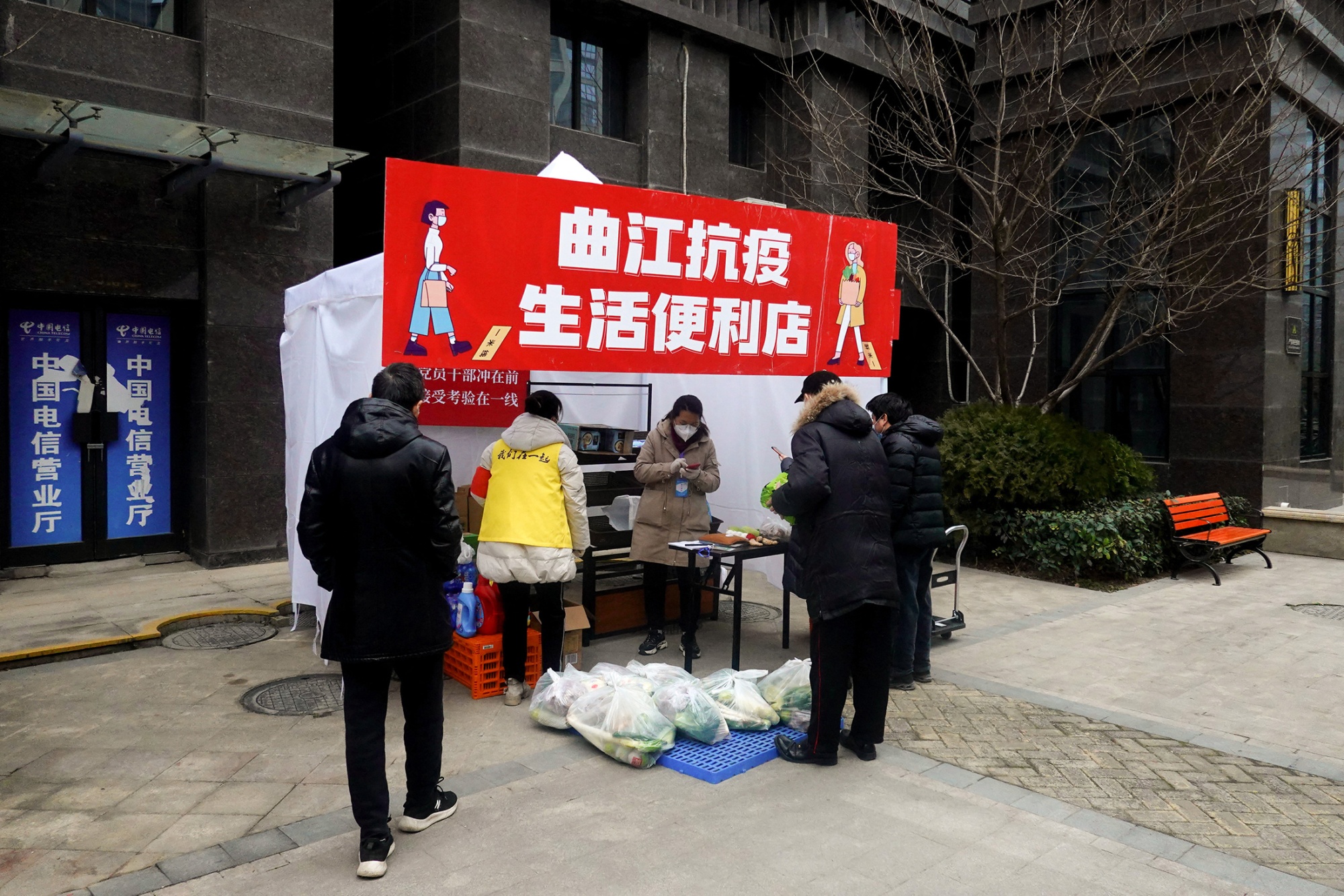 Residents buy food and daily necessities at a temporary stall set up in a residential compound in Xi’an on Jan. 6.