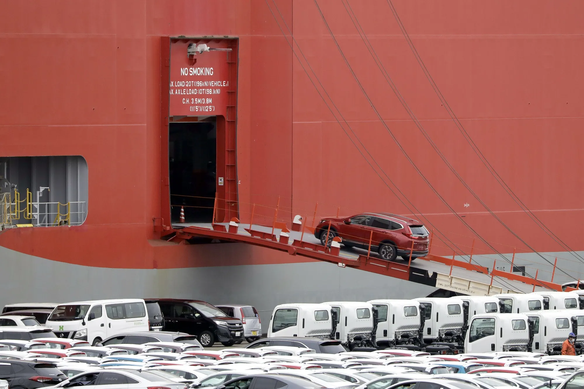 A vehicle bound for shipment is driven onto a vehicle carrier, operated by Kawasaki Kisen Kaisha Ltd., at a port in Yokohama in Japan.