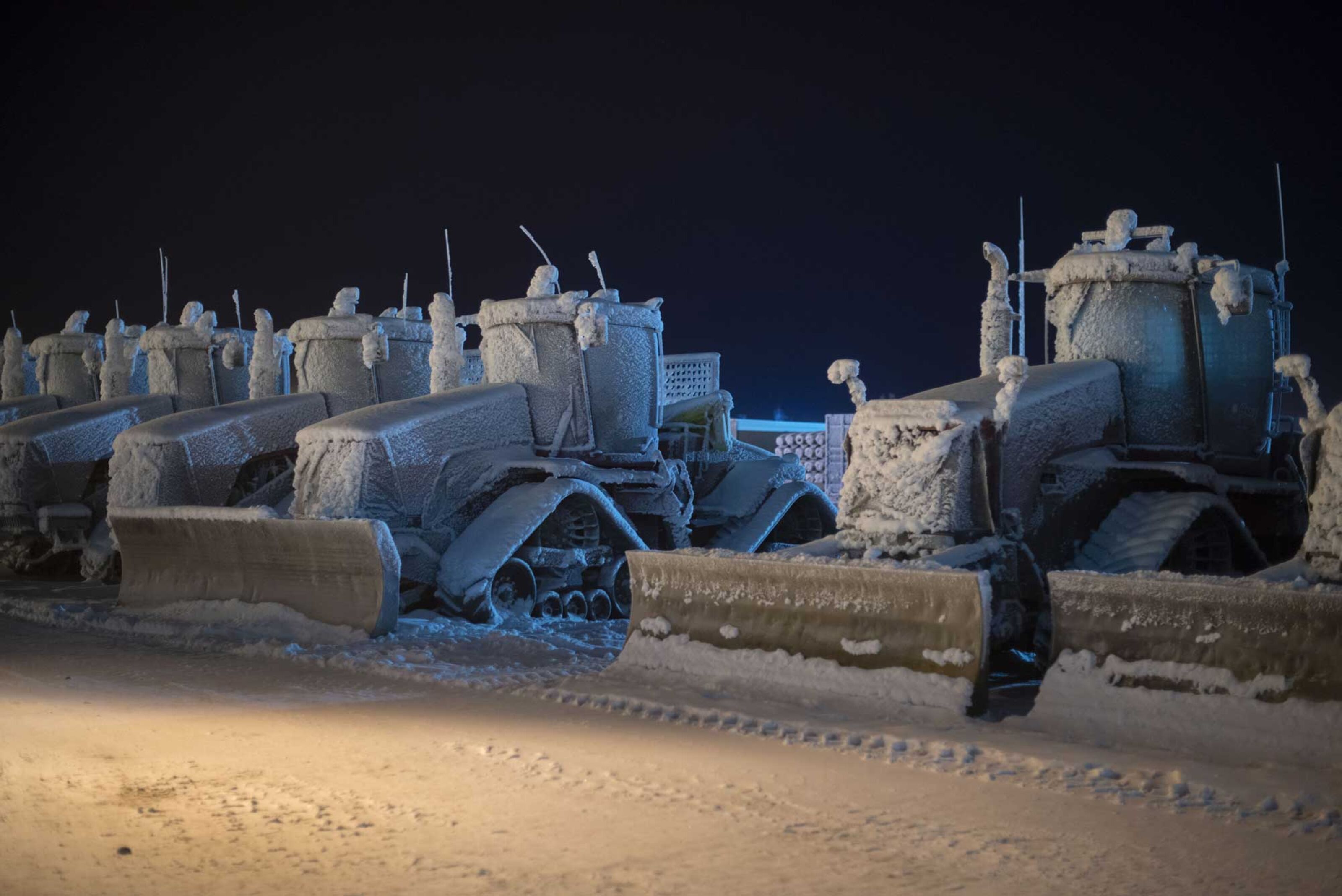 A row of bulldozers used at North Slope oil fields, covered in a thick layer of frost, parked at Deadhorse, Alaska, in December 2016.