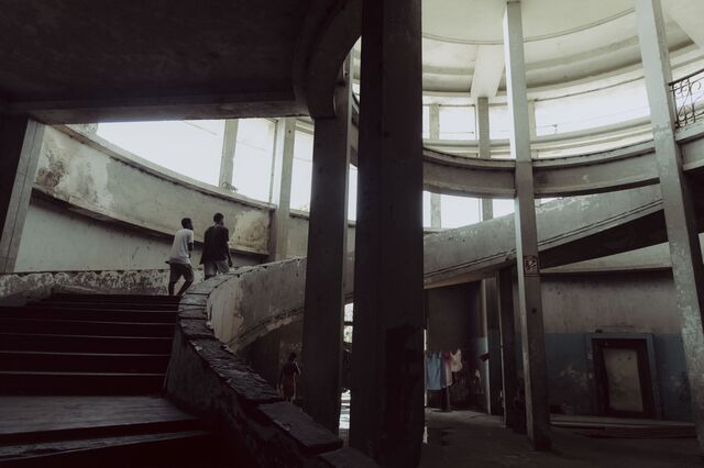 Residents walk up a decaying staircase at the former Grande Hotel. 