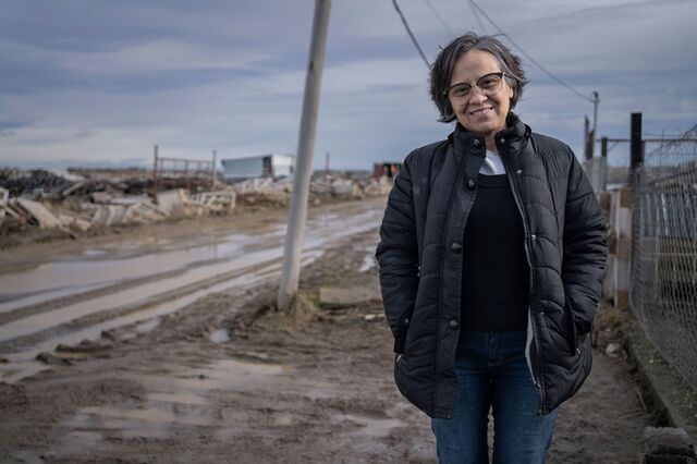 A portrait of Maria Elizabeth Leyes standing outside on a muddy street. 