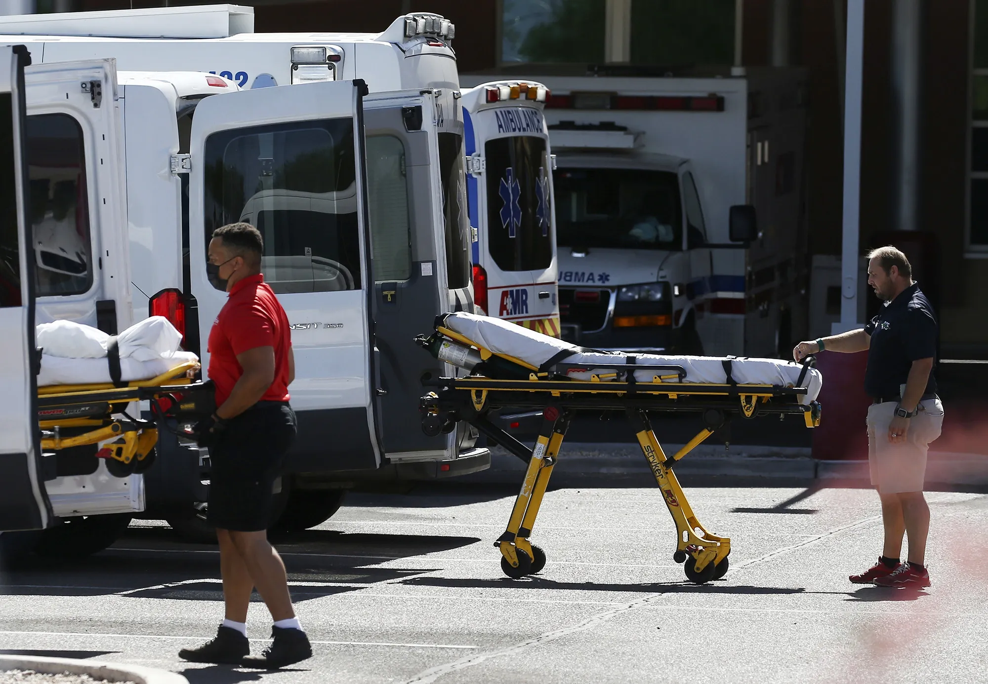 Medical transports and ambulances are parked outside an emergency-room at a hospital in Mesa, Arizona, on June 16.