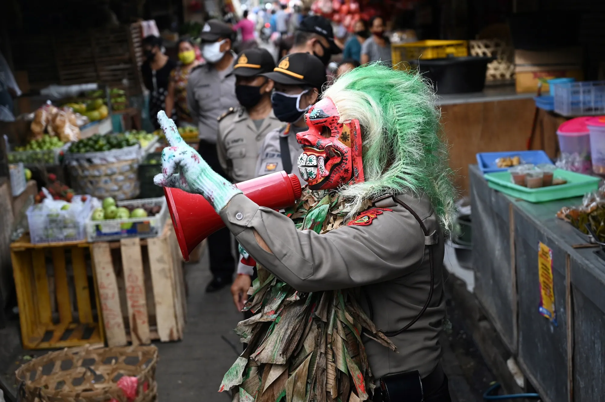 A police officer wears a mask called "Leak" while educating people on coronavirus matter at a market in Kerobokan, May 14.