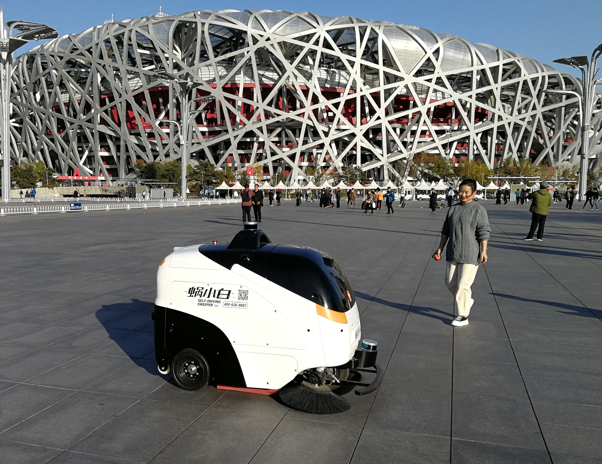 ‘Woxiabai’ cleans the ground near Beijing National Stadium in 2019.