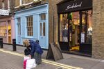 A shopper packs a bag outside retail stores in&nbsp;London, U.K.
