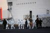 People wearing protective suits walk from the Diamond Princess cruise ship, with around 3,600 people quarantined onboard due to fears of the new coronavirus, at the Daikoku Pier Cruise Terminal in Yokohama port.