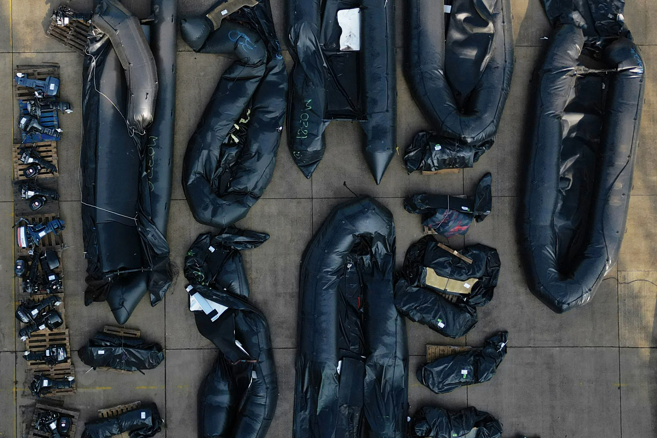 Inflatable dinghies and outboard engines stored in a Port Authority yard in Dover, England, that are believed to have been used by migrants who were picked up at sea whilst crossing the English Channel from France last month.