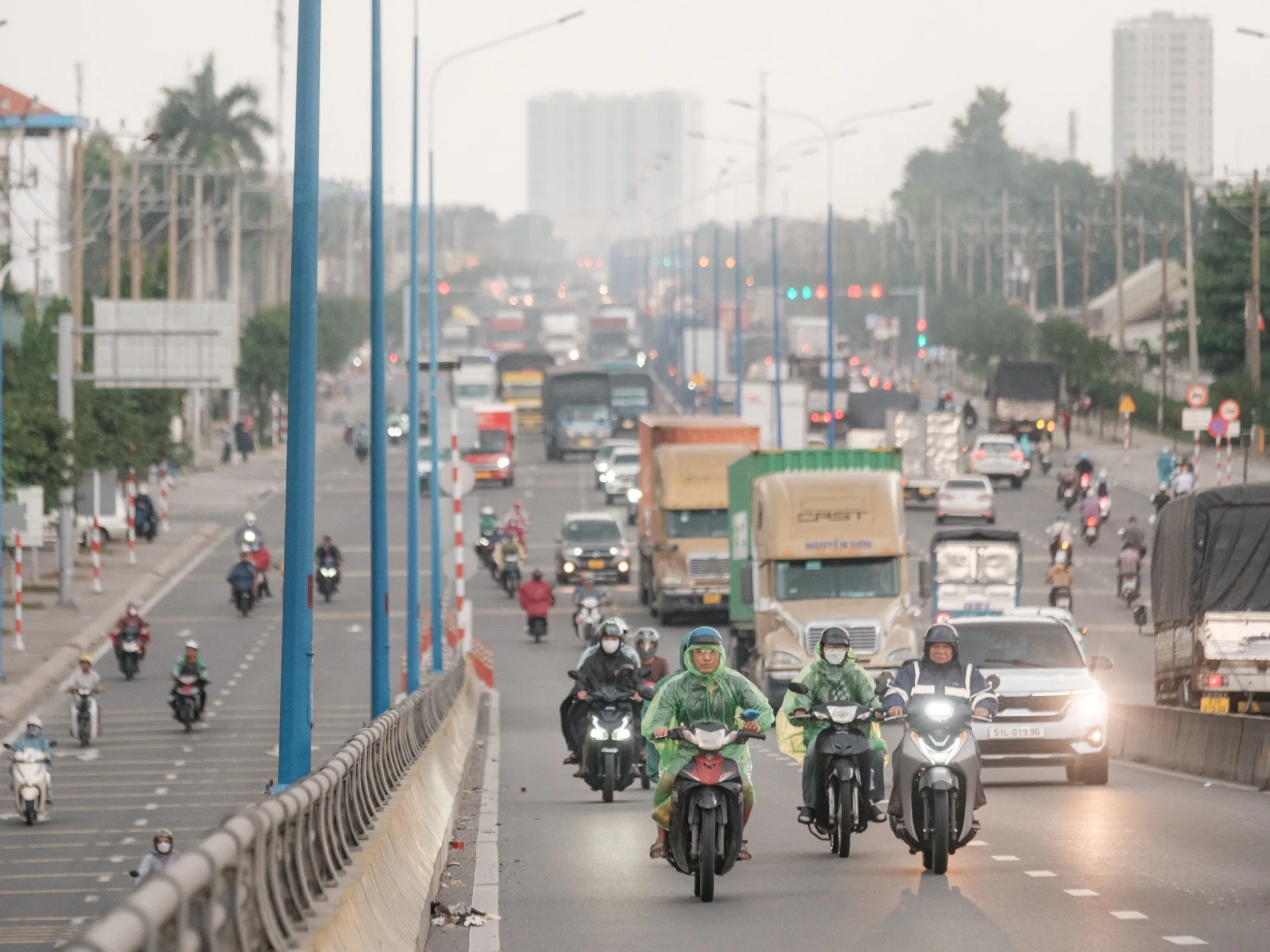 Motorcyclists and trucks in Binh Duong City in Vietnam.