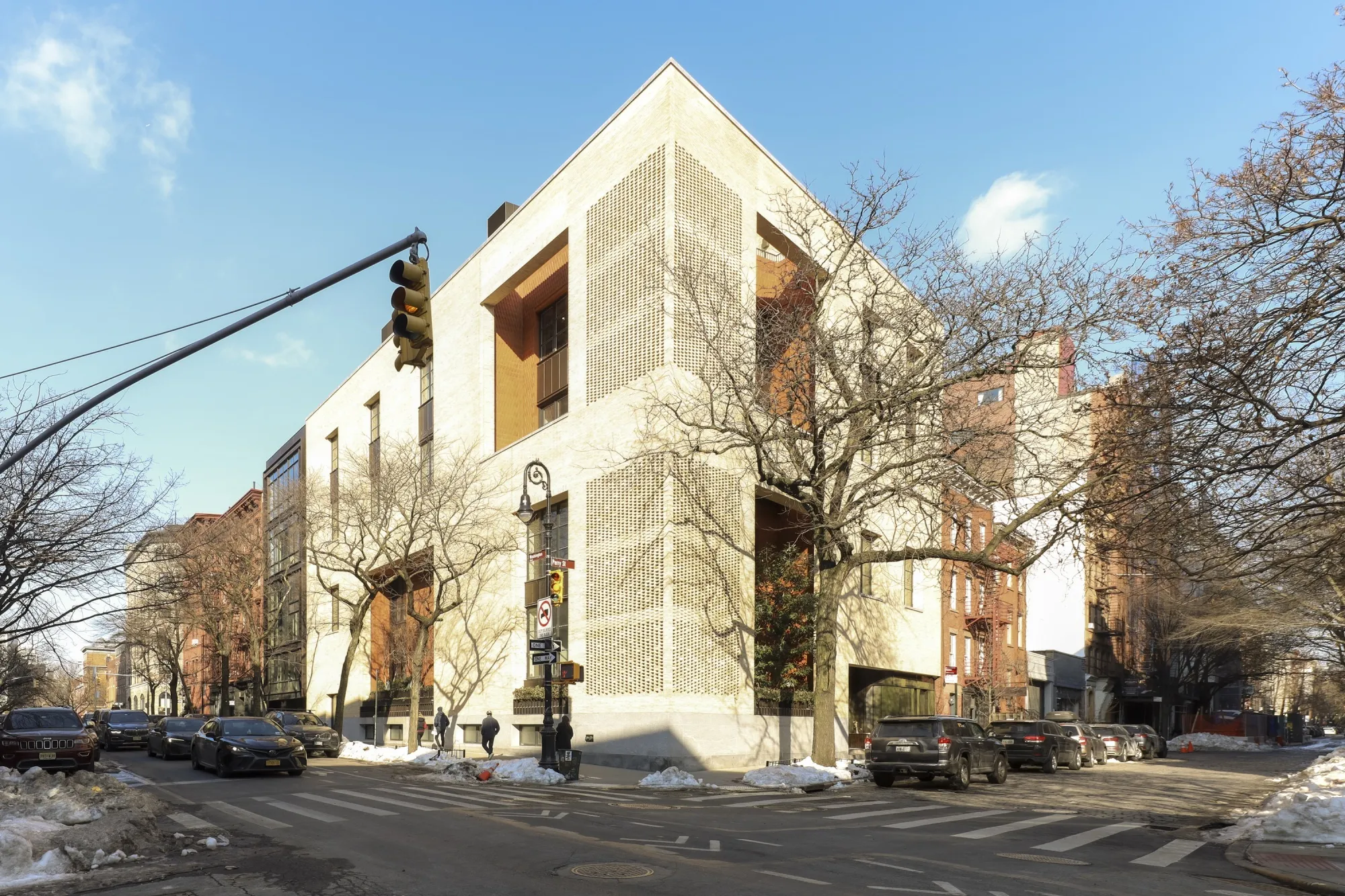 A corner view of a mega-mansion in New York with a beige facade.