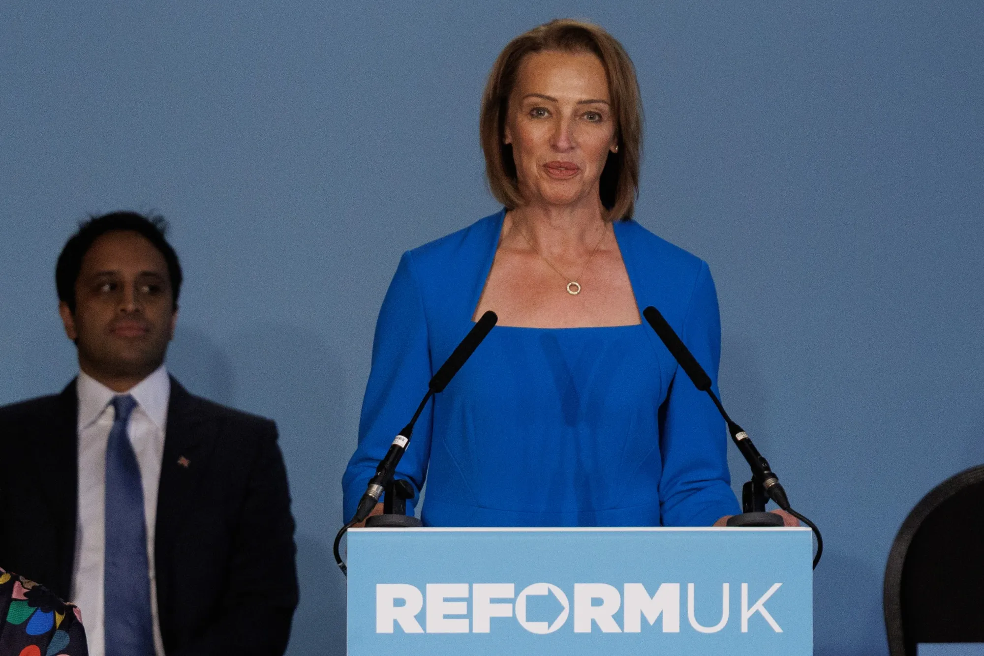 Zia Yusuf sits behind Sarah Pochin as she speaks at a Reform UK press conference in May.