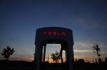 A Tesla Inc. Supercharger station stands illuminated at dusk in Rubigen, Switzerland.