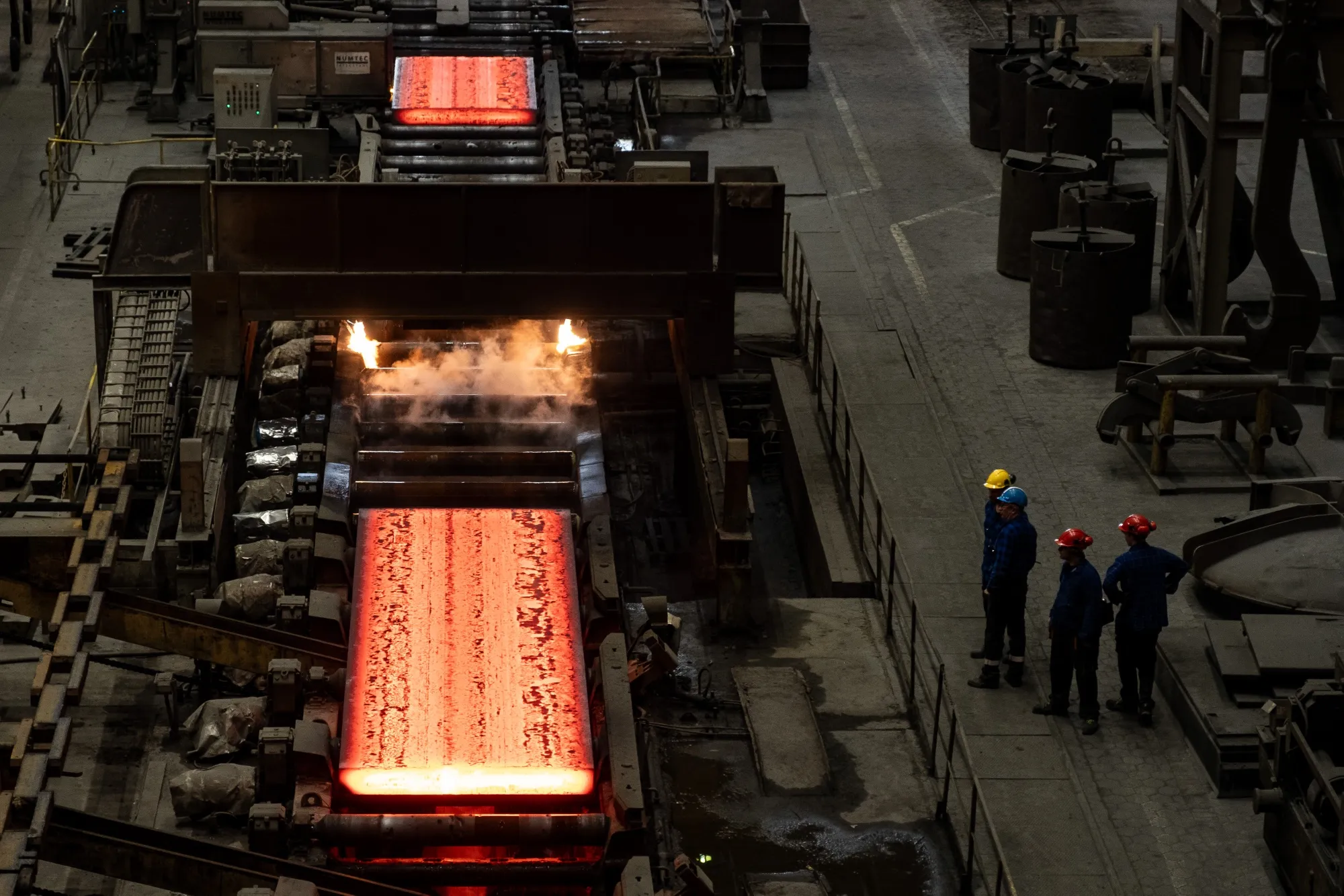 Red hot steel slabs on a conveyor belt at a steel smelter in Poland.