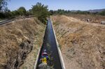 A government official measures water flow in Maule, Chile.