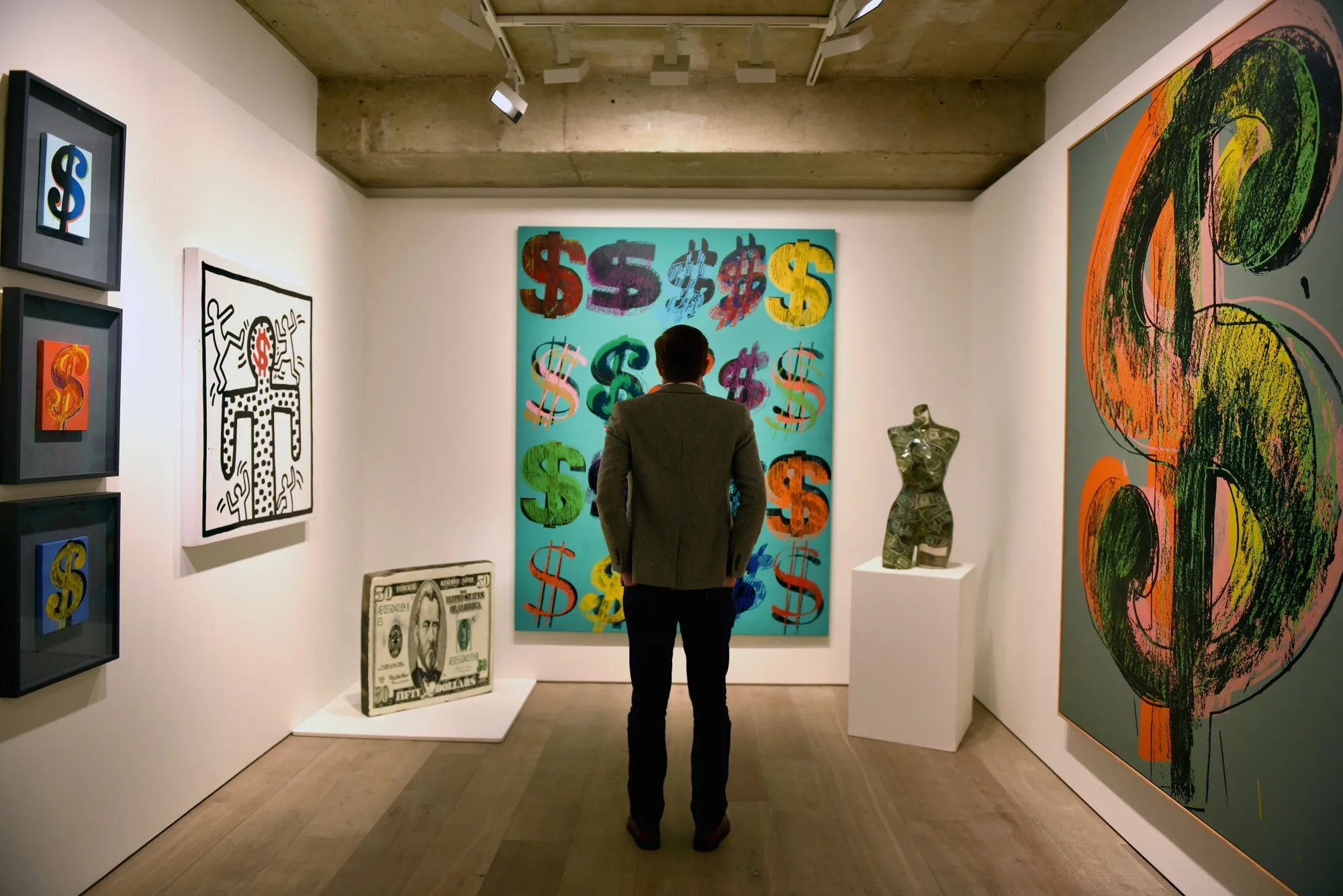 A visitor studies 'Dollar Signs', 1981, by Andy Warhol at Sotheby's in London.