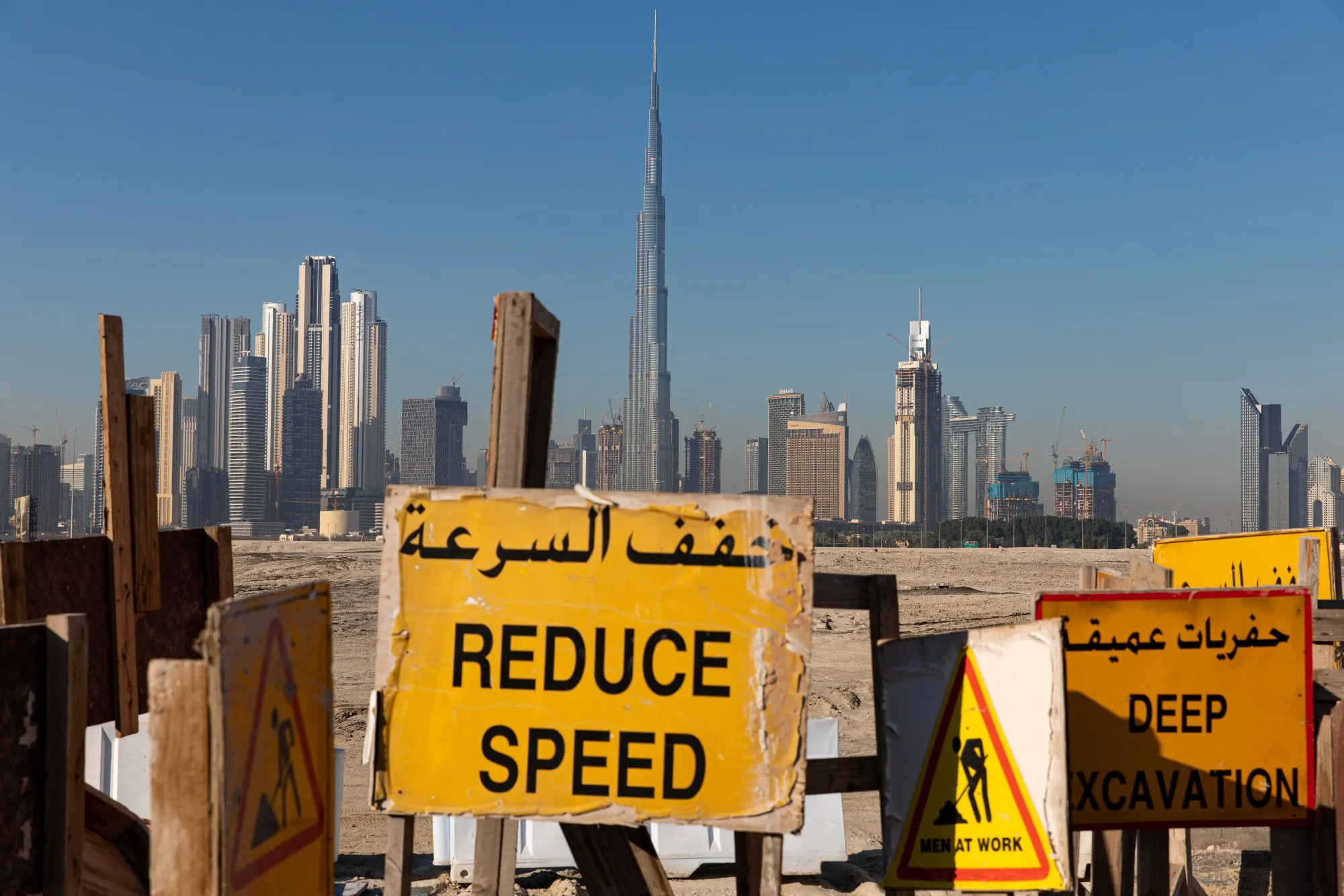 Multiple traffic warning signs for construction works stand on undeveloped land&nbsp;in Dubai.&nbsp;