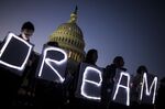 Demonstrators hold illuminated signs during a rally supporting DACA in Washington, D.C.