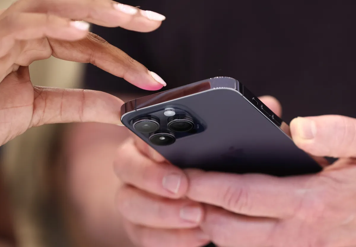 نمایی نزدیک از یک آیفون که سیستم عامل iOS 16 را نمایش می‌دهد.