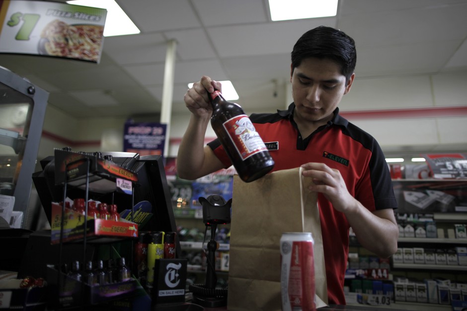 Abel Santiago serves a customer at a 7-Eleven convenience store in Santa Monica, California.