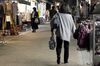 Pedestrians and shoppers walk through the Yanaka Ginza shopping street at dusk in the Yanesen district of Tokyo, Japan.