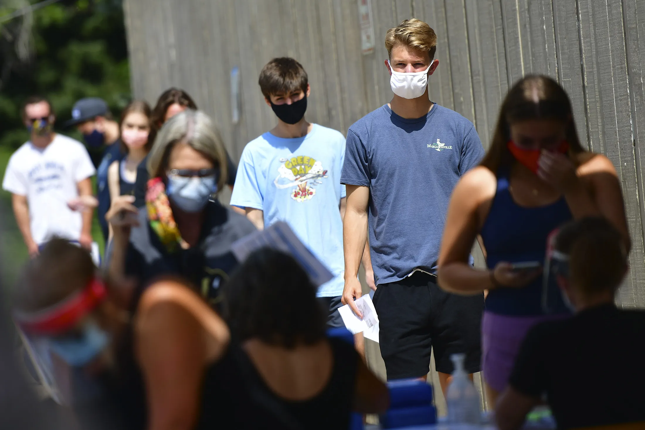 Students wearing protective masks wait in line for registration at the University of Colorado at Boulder.