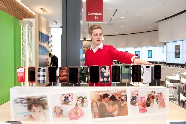 Verizon Wireless employee Alex Wegehaupt explains how smartphone cases can be personalized in the Customize It Zone at the Verizon Destination Store at Mall of America in Bloomington, Minn., on Nov. 19