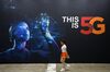 A woman walks past an advertisement for SK Telecom Co. at the World IT Show 2018 in Seoul.