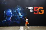 A woman walks past an advertisement for SK Telecom Co. at the World IT Show 2018 in Seoul.