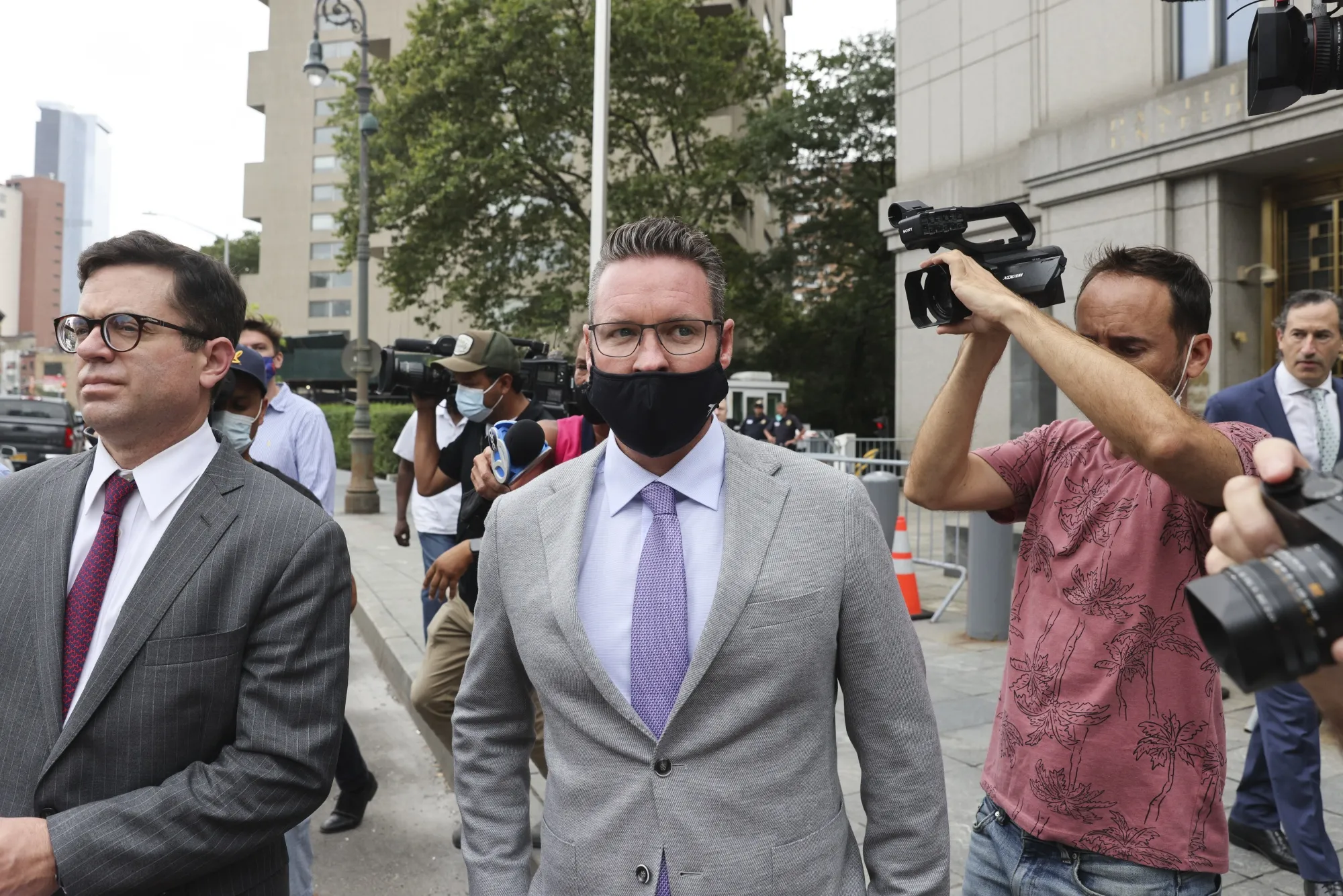 Trevor Milton, center, exits federal court in New York, on July 29.