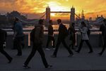 Commuters walk across London Bridge in London, U.K.