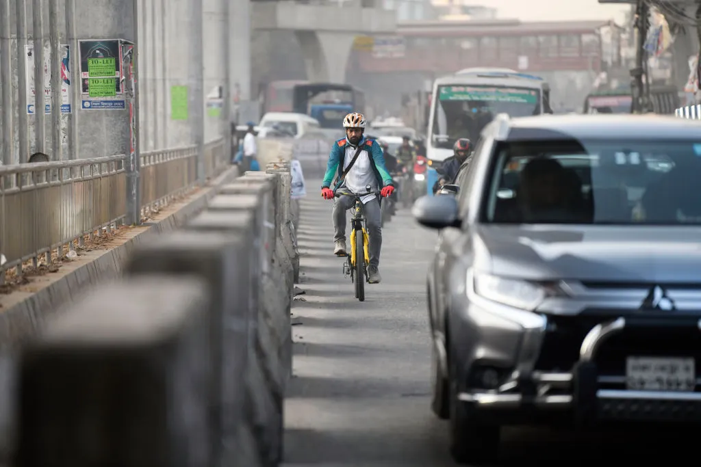 A cyclist rides at the edge of a car lane&nbsp;in Dhaka.&nbsp;