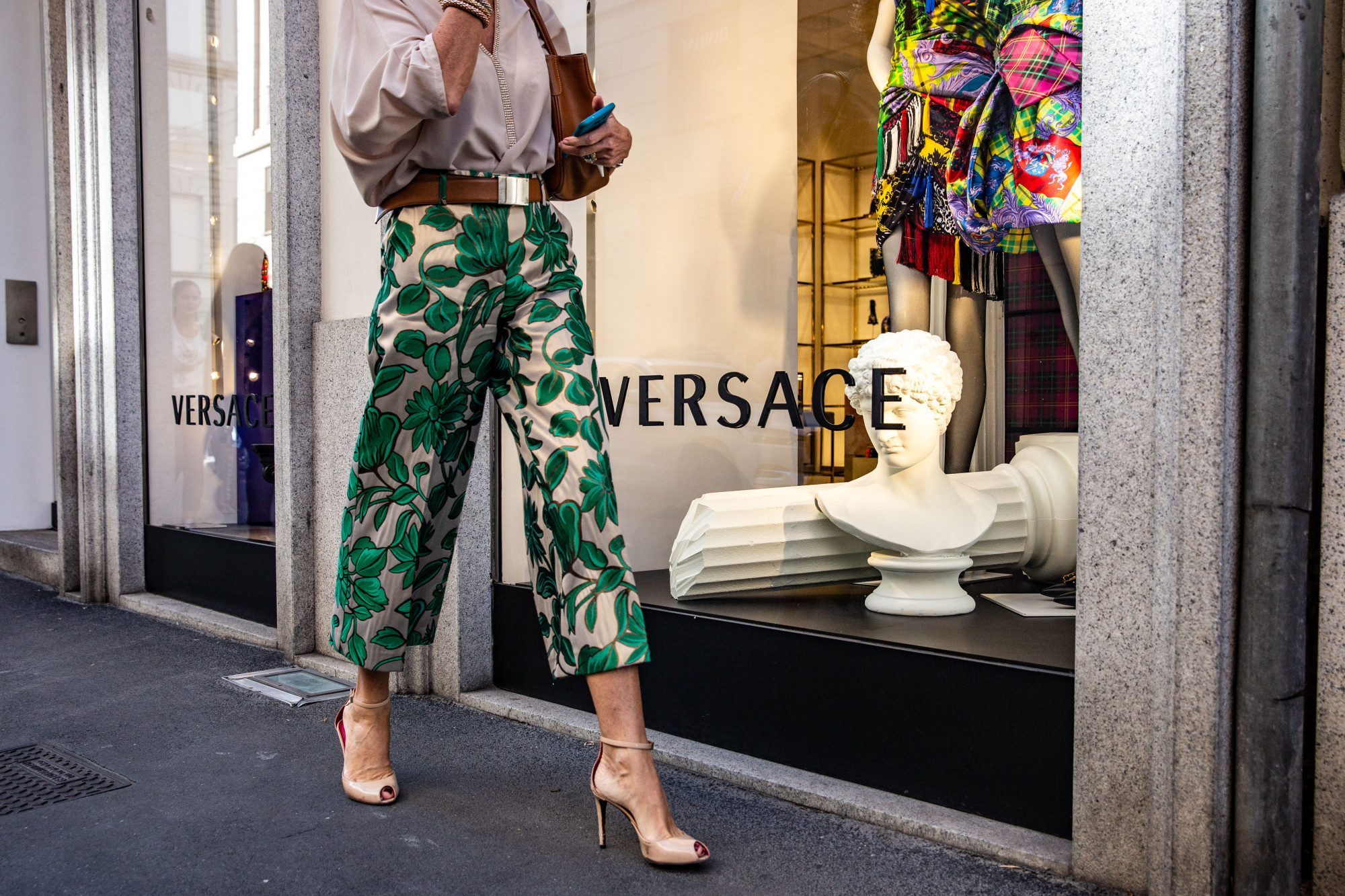 A pedestrian passes a Versace store in Milan.