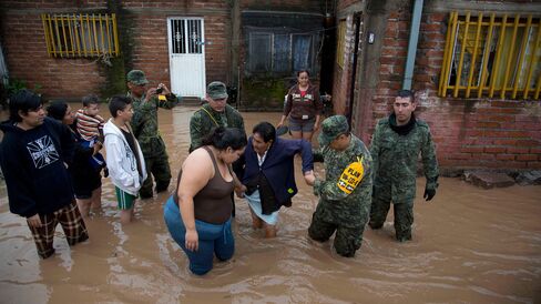 Soldiers help a woman to leave her flooded house in Zoatlan, Nayarit state, Mexico, on Oct. 24.