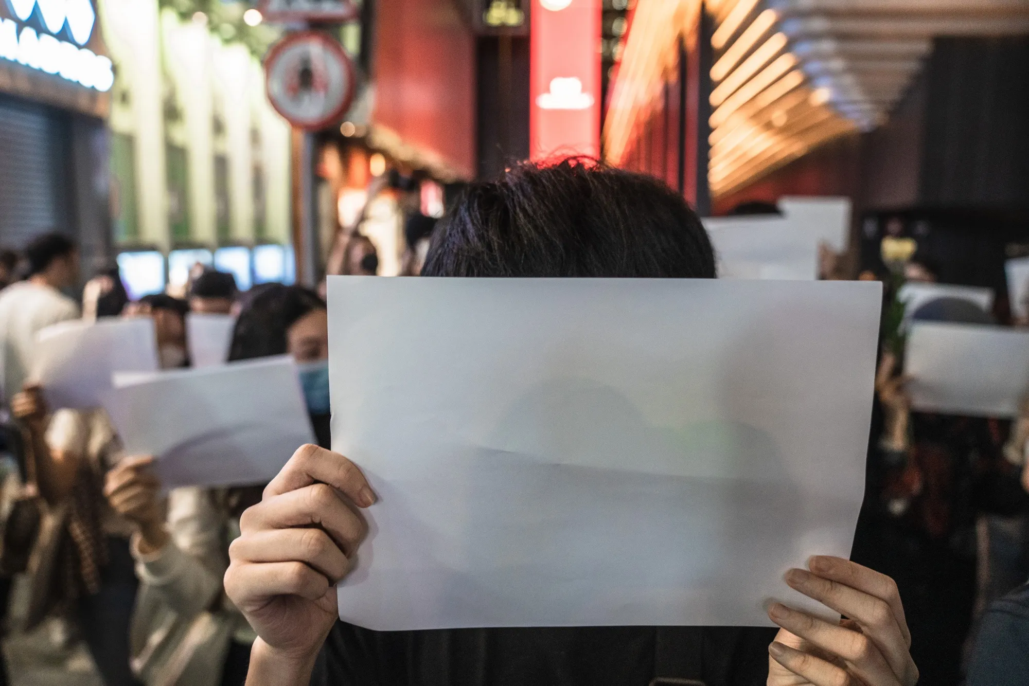 Demonstrators hold blank protest signs during a vigil commemorating victims of China's Covid Zero policy in Hong Kong, China, on Monday, Nov. 28, 2022.&nbsp;