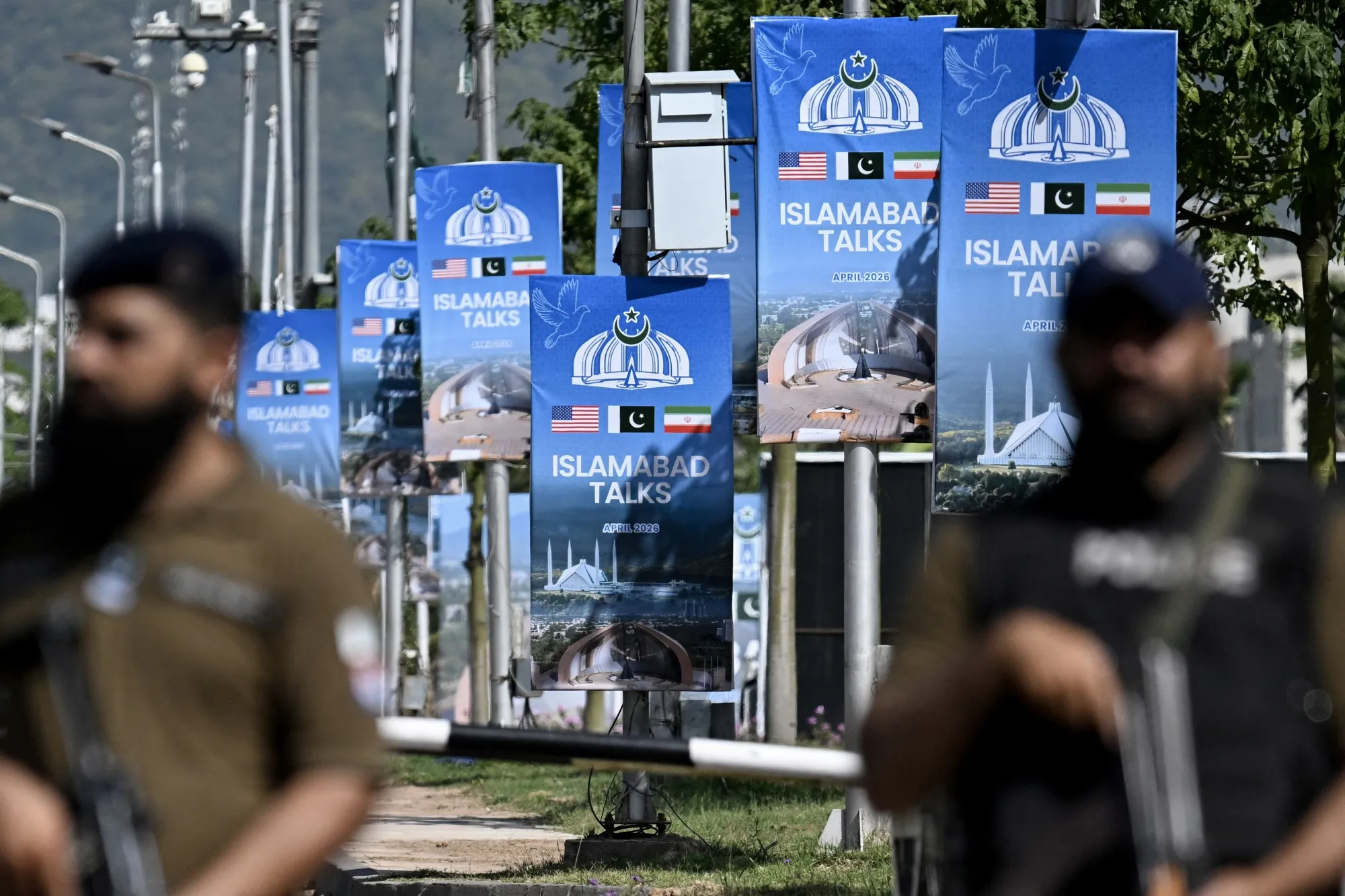 Security personnel stand guard at a security check post along a road temporarily closed near the Serena Hotel at the Red Zone area in Islamabad on April 20.